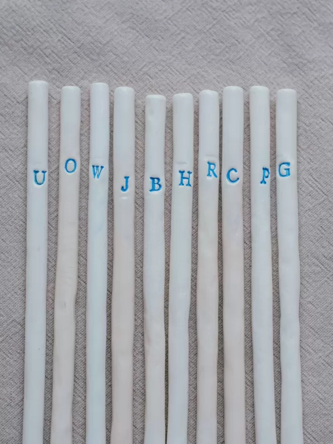 Monogrammed Ceramic straws laid out on a napkin.