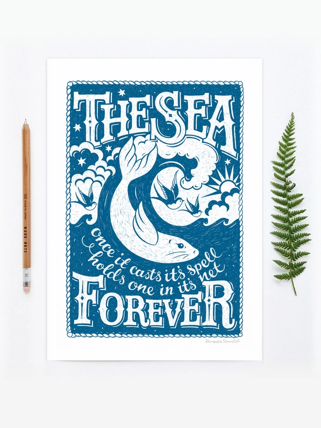 blue and white sea print unframed with fern and pencil