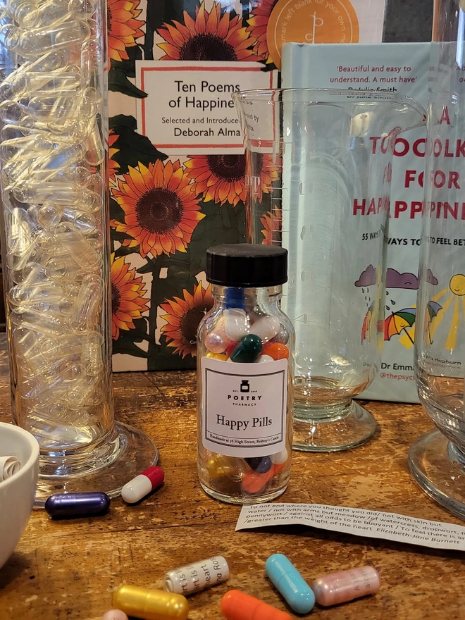 Glass pill bottle containing multi-coloured Happy poetry pills printed on banana paper