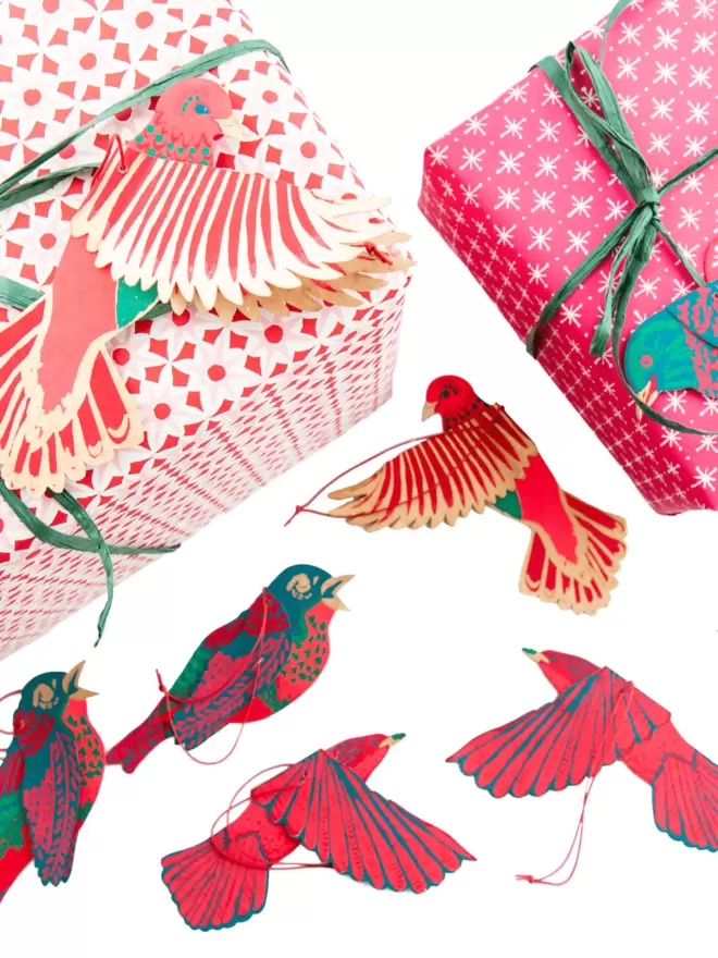 Christmas set-up with brightly packaged gifts and beautiful, pink paper birds