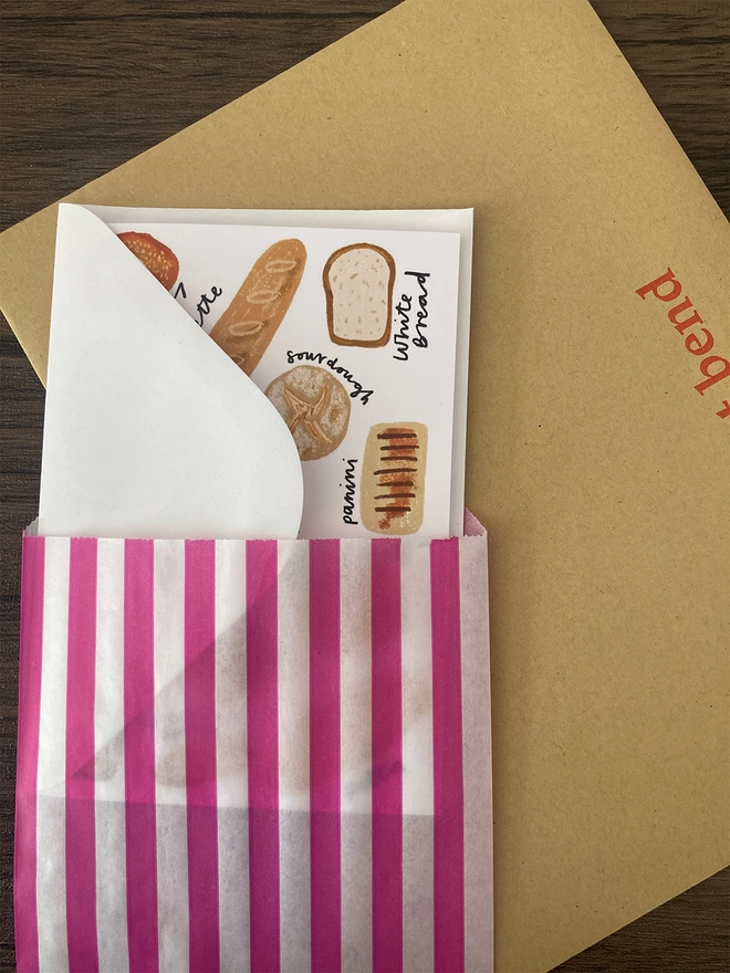 Bread card packed with a white envelope inside a paper bag