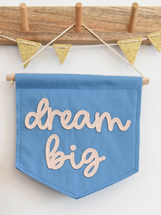 felt banner with the words dream big sewn on in cursive text.