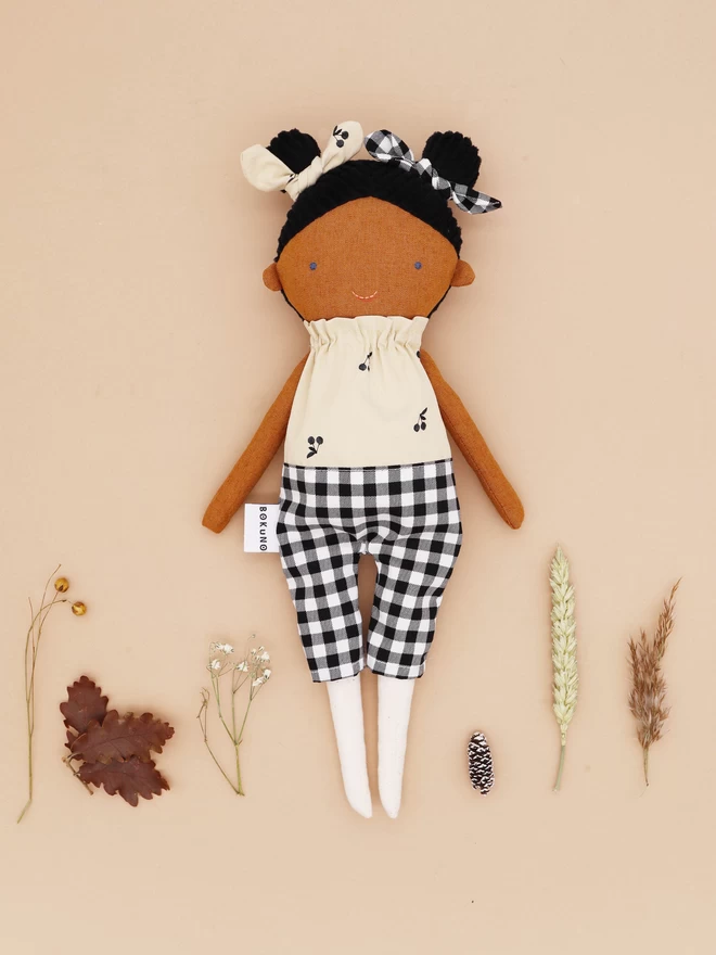 brown skin doll with double bun hair style in cherry and gingham outfit 