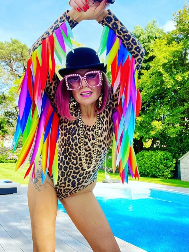 A Leopard Print Leotard with gold sparkle, made with Econyl. Long sleeves and Rainbow feather effect wings 