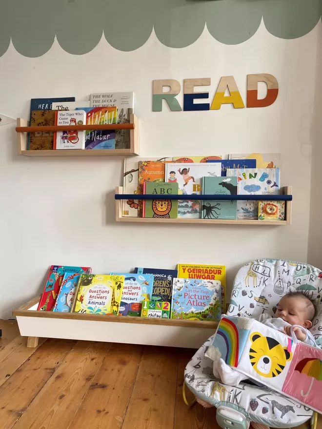 Autumn's Corner Flip-It Shelf seen along with the reading trough in a room with a baby.
