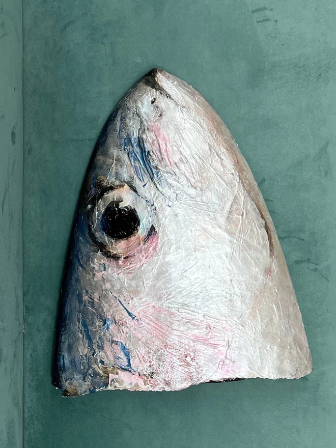 an original painting of a sardine fish face onto the broken nose part of a repurposed surfboard