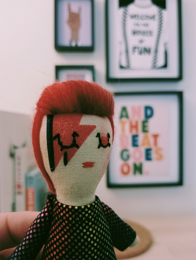 Close up of David Bowie mini decorative doll showing hand embroidered face details and red flash makeup