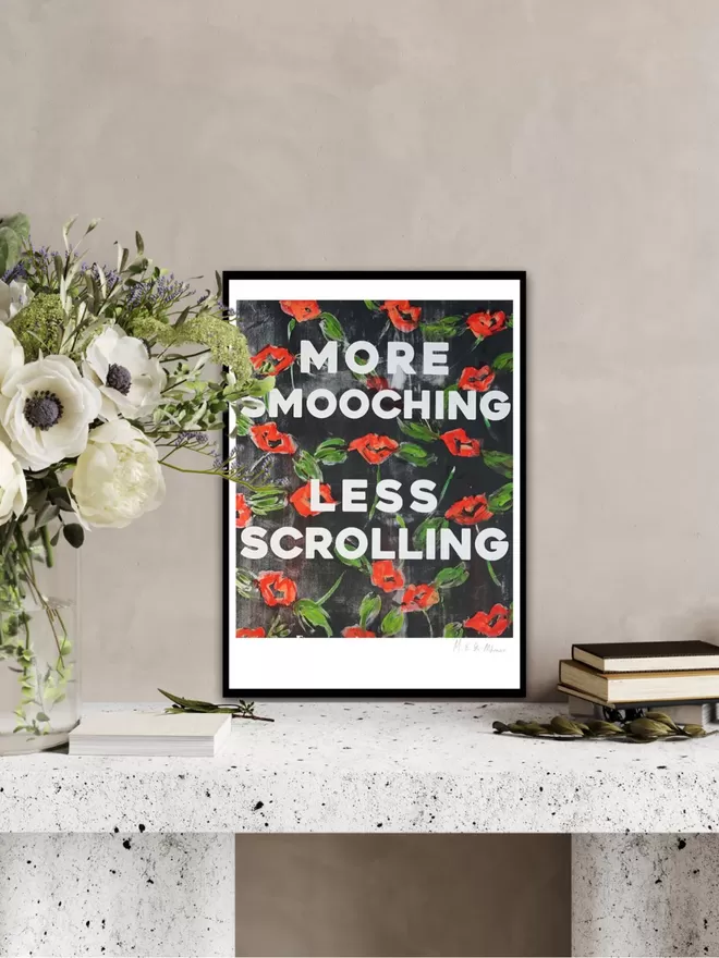 MORE SMOOCHING, LESS SCROLLING fine art print.  Based on an original monoprint by M.E. Ster-Molnar.  Shown on an Art Deco marble desk with anenome flowers and beige wall.  