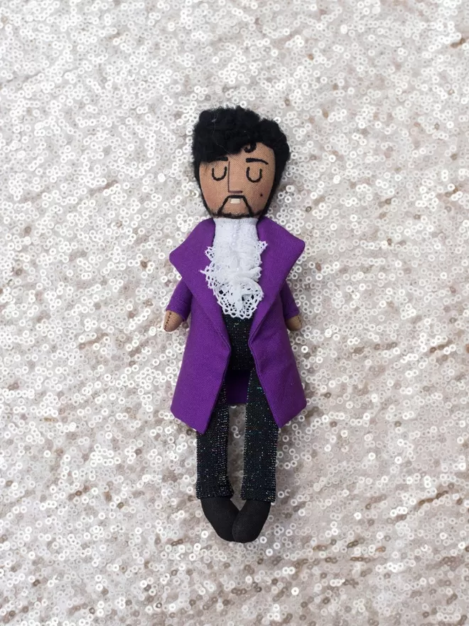 Prince Doll seen on a sequin background.