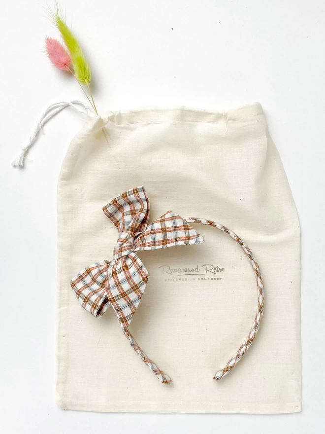 Alice Band with large Bow in Rust and cream gingham on gifting bag 