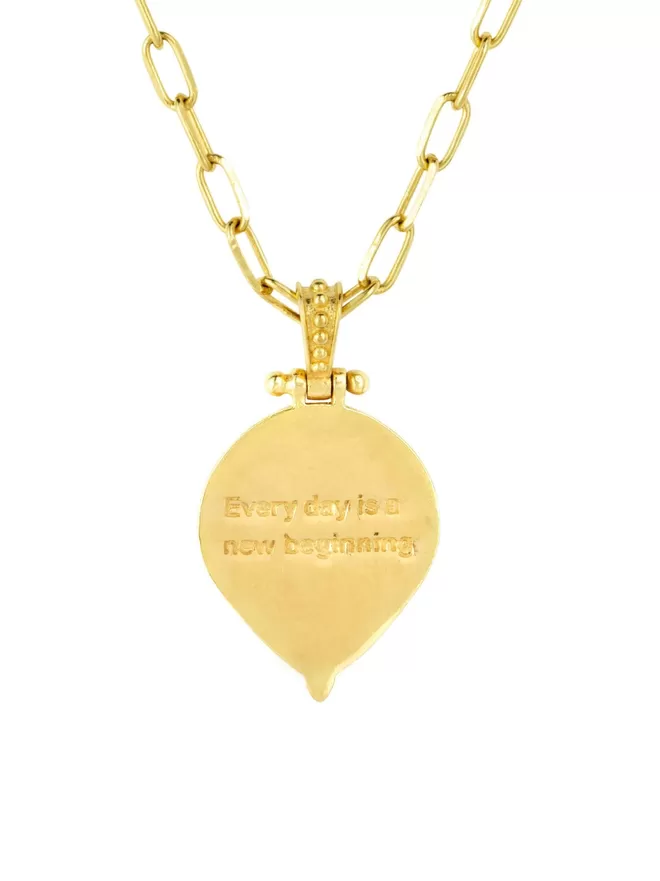 Reverse of gold pendant with engraved message Every day is a new beginning