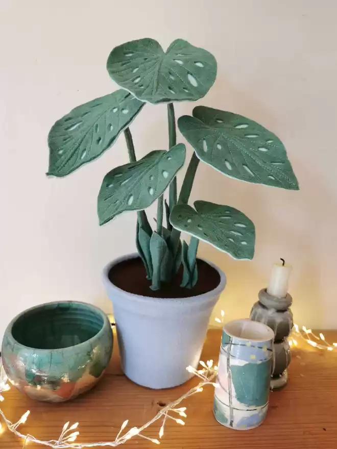 Sage Green Spotty Begonia Felt Faux Potted Houseplant seen with fairy lights.