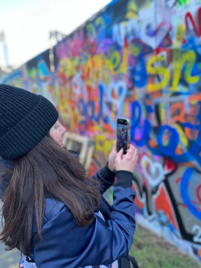 Evi Antonio artist taking photos of graffiti love hearts around Brick lane, East London to use in her artwork.
