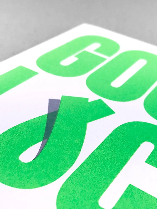 Close up of the good luck greetings card design showing the green lettering with the grey shadow printed to make the U look like it is overlapping.