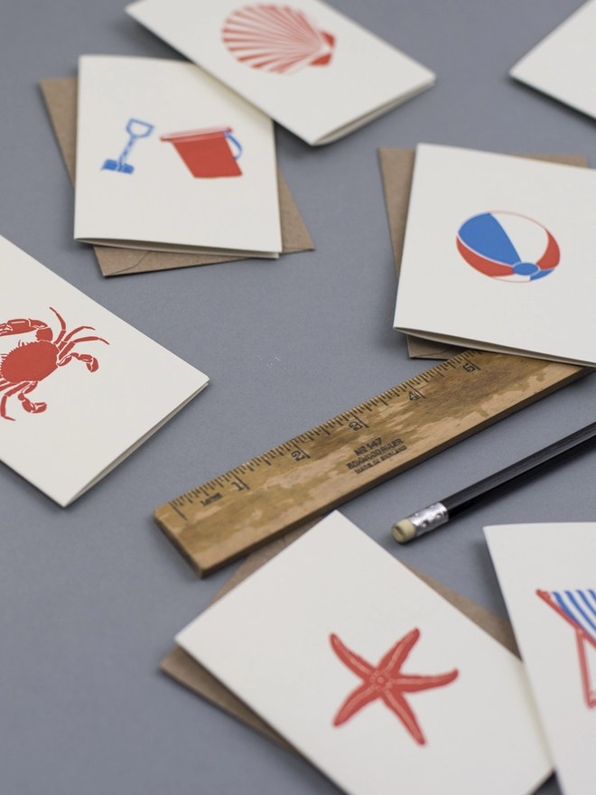 Close up image of the small cards with envelopes showing the shell, starfish, beach ball and crab 