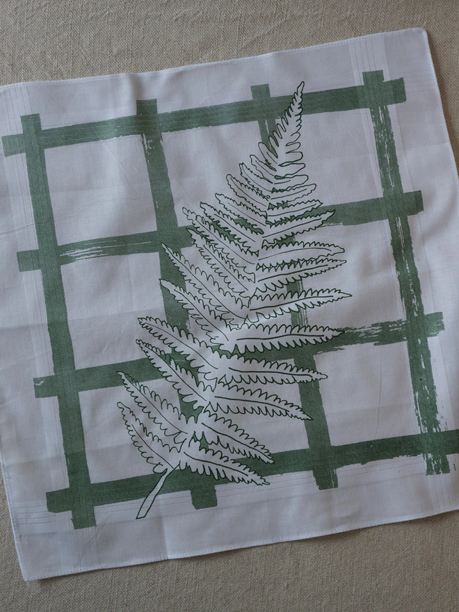 A Mr.PS Fern leaf hankie laid flat on a linen tablecloth