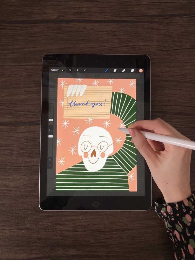 Hand drawing on an iPad using an Apple Pencil, the illustration is a skeleton saying thank you