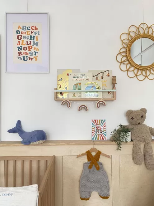 Autumn's Corner Bookshelf filled with books, seen in a child's room with a handmade wooden cot.