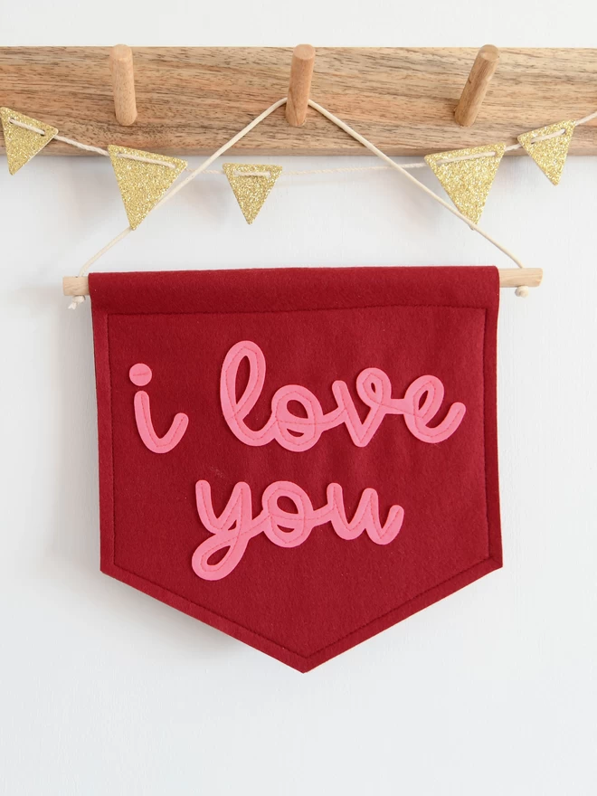 mini felt banner with i love you written on in pink cursive text.