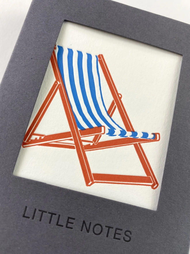 Close up of the gift box window showing the blue and white stripped deck chair with orange legs, all made in the UK