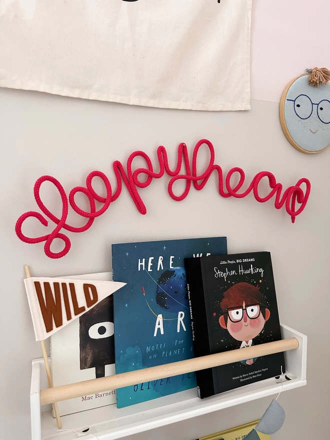 "Sleepyhead" sign for over the bed hanging up over a book shelf in a play room. 