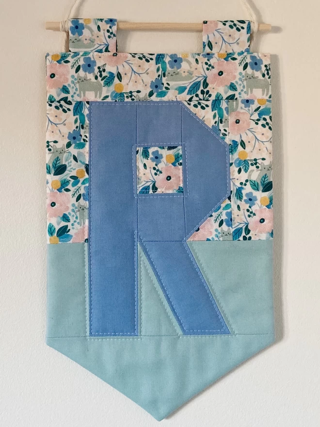 Cooper and Fred colour block quilted wall hanging with floral and green background and blue letter 'R'