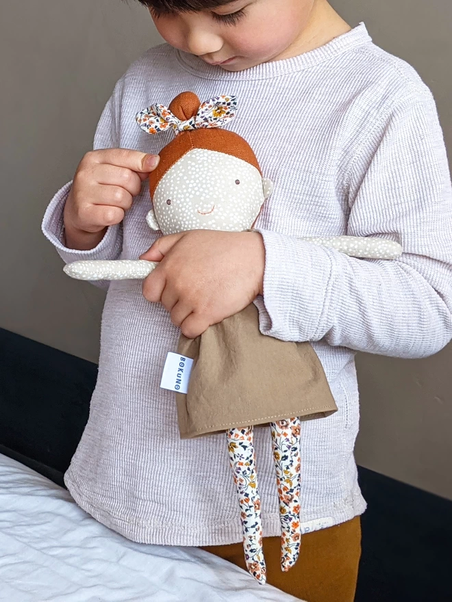 boy playing with fabric girl doll with freckles