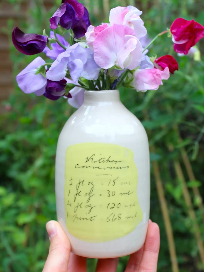 handmade ceramic bottle vase with sweet peas and decorated with handwritten text