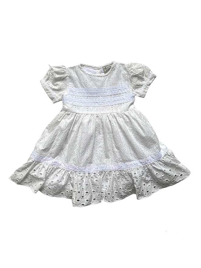 A white short sleeved dress with two different broderie anglaise fabrics and white lace detailing