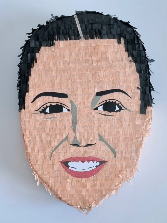 custom made face pinata by pinyatay of a white woman with pulled back black hair