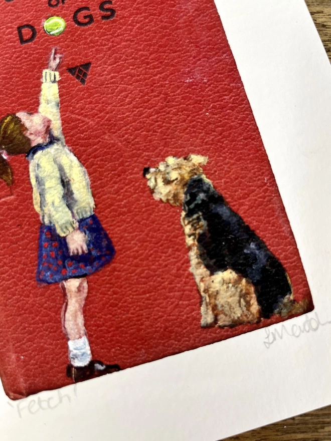 a print of an aged  red observer book with a little girl pointing to a tennis ball while an airedale or welsh terrier looks up painted on to it.