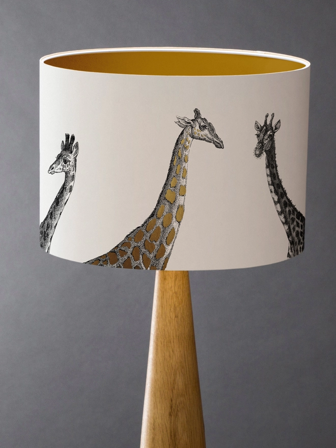 Drum Lampshade featuring Giraffes with a gold inner on a wooden base 
