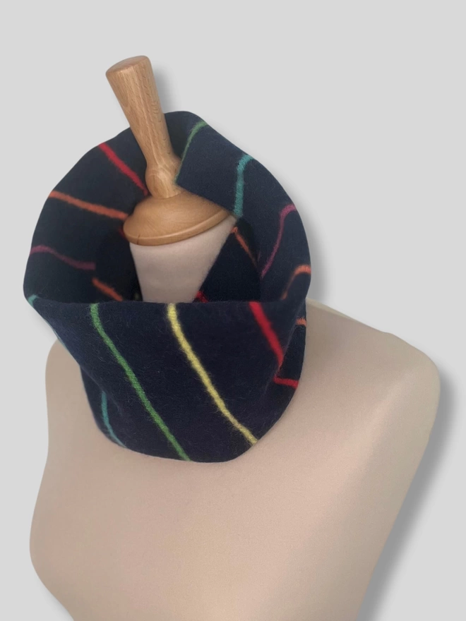 Navy knitted snood with colourful thin stripes shown on a mannequin