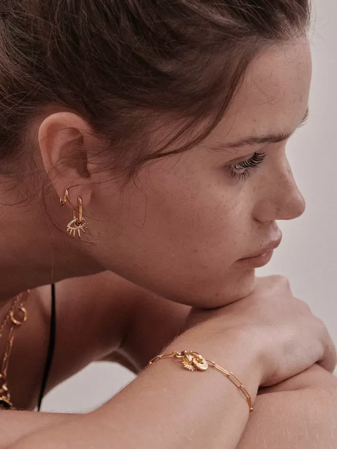 woman wearing gold earrings with charms