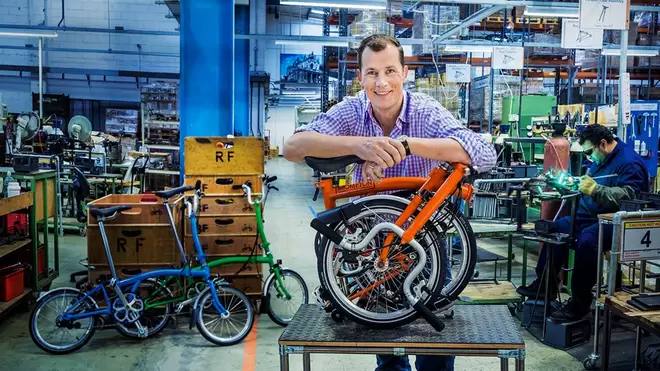 Will Butler-Adams OBE, CEO of Brompton Bikes, smiling at the camera holding a bike.