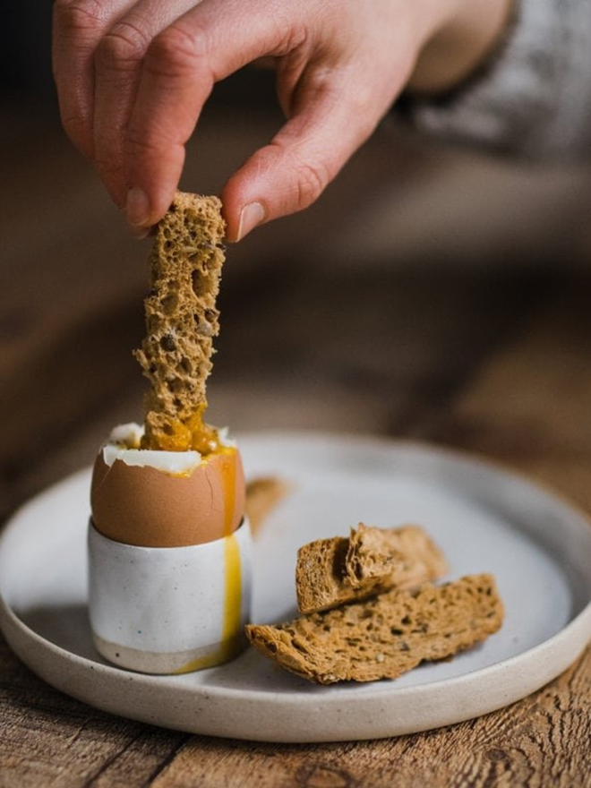 handmade clay egg cup with boiled egg and toast soldiers