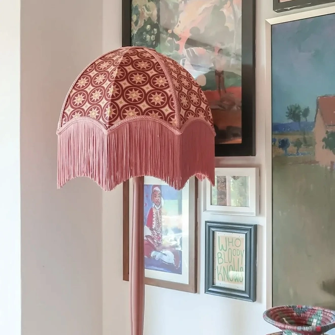 Fringed pink lampshade with a geometric patterned fabric