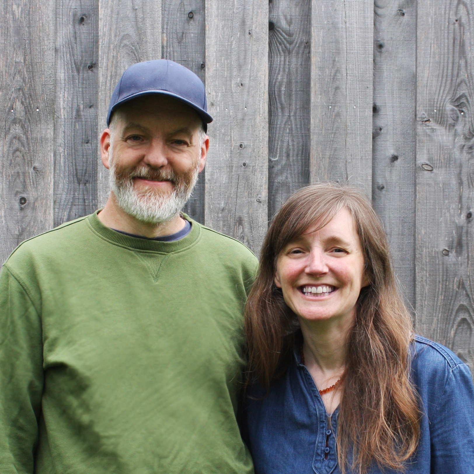 Rho Rho Illustration founders Thomas and Bridget Rhodes in front of wood clad wall