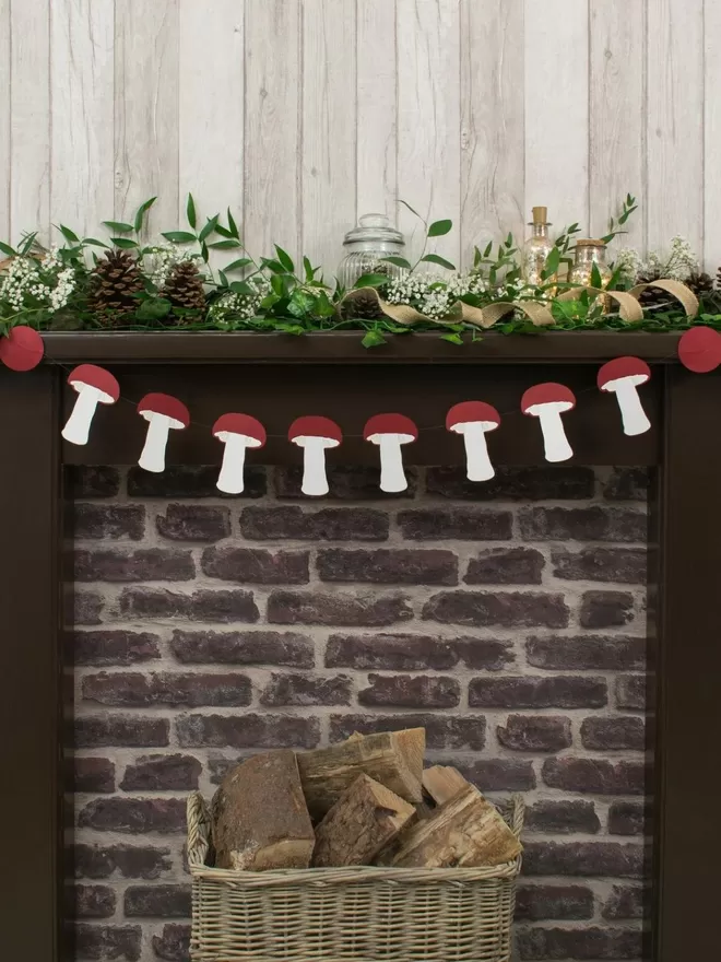 Mushroom Paper Bunting strugs across a mantelpiece decorated with greenery