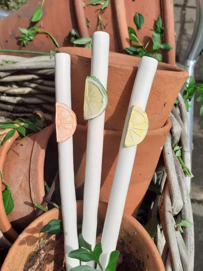 Lemon, Lime and Orange slice ceramic drinking straws in a stack of antique Victorian terracotta flowerpots