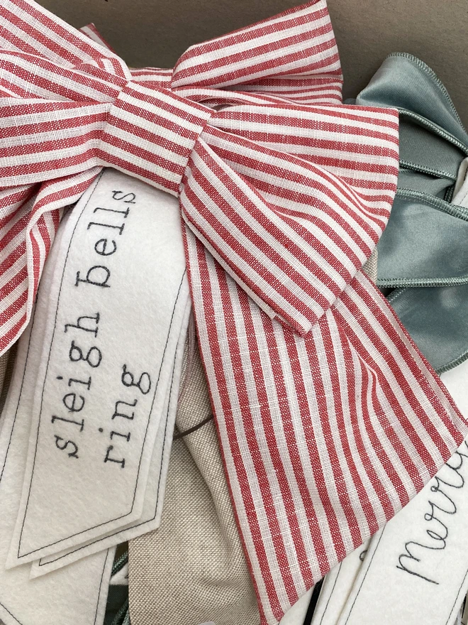 Red stripe bow with text, sleigh bells ring