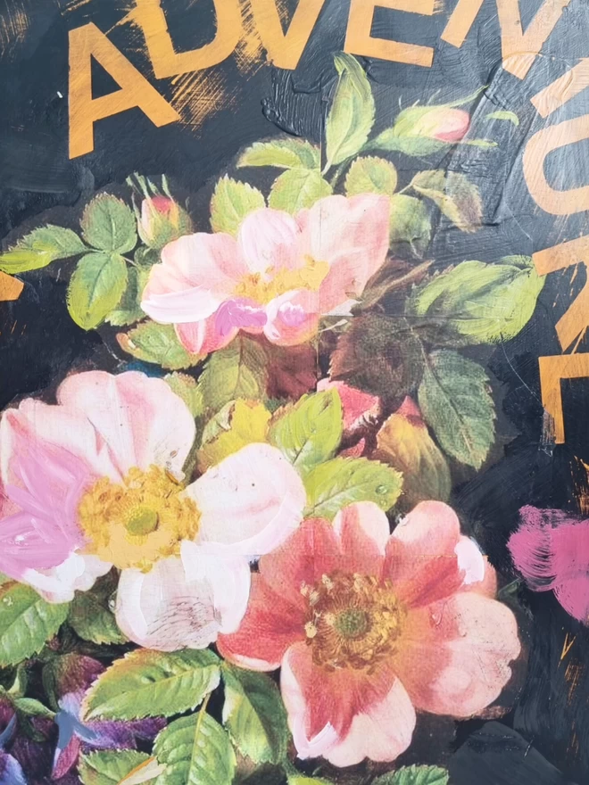 Large painted wall panel in black with large decoupage wild roses and orange text reading ‘go on an adventure’.