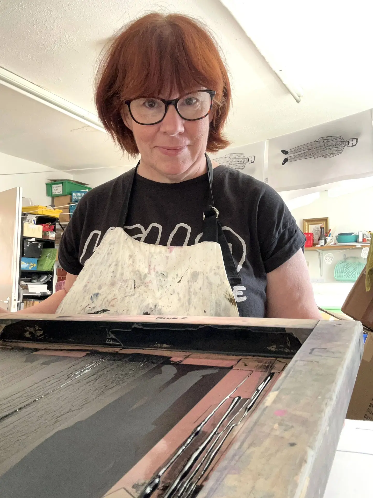 Artist and small business owner, Susan McKenna, in an apron stood at a screen printing table.