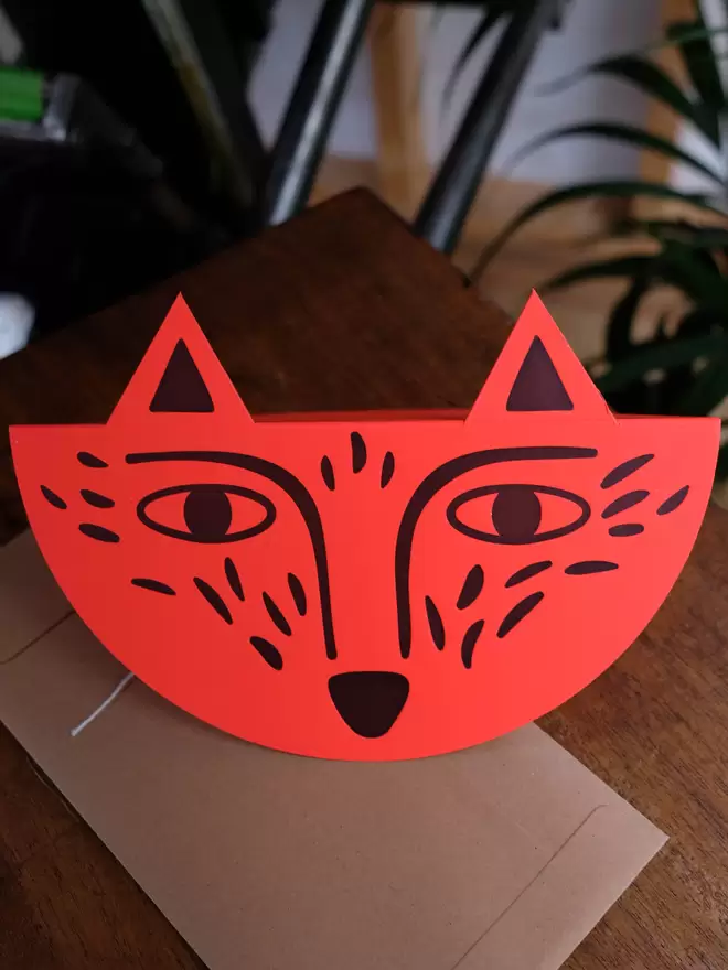 Bright red letterpress printed fox card with stick-up ears. Standing on table with string and washer envelope.