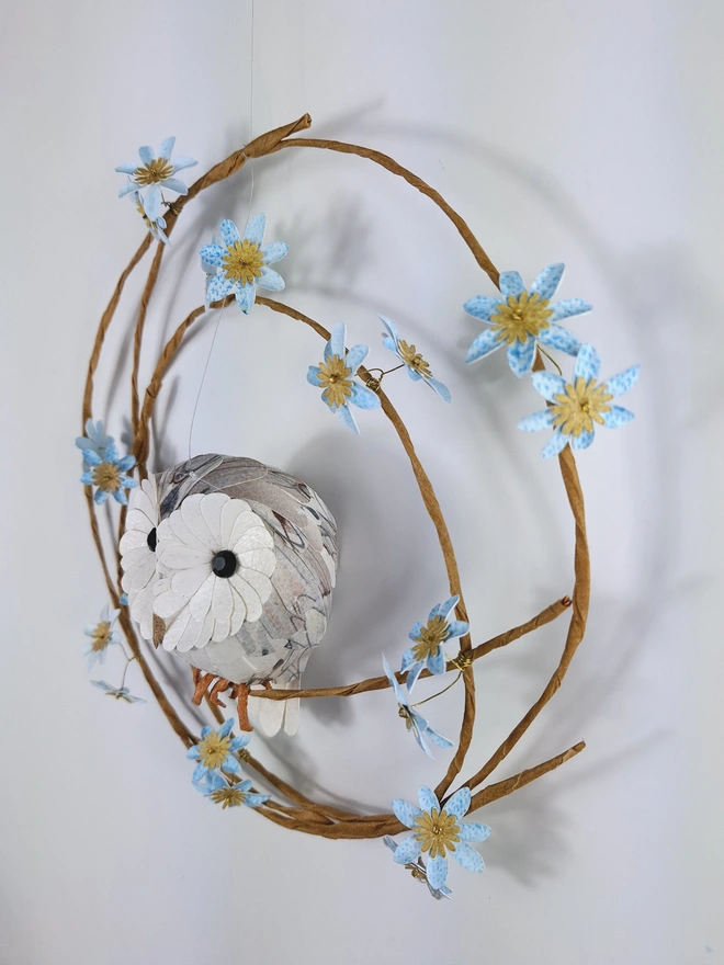 side view of a handmade owl sculpture, depicting a baby barn owl