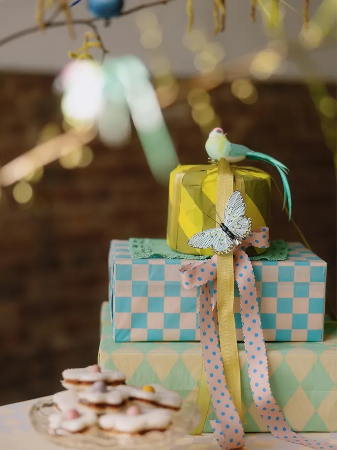 Luxury tissue paper wrapped gifts with ribbons and bird and butterfly clips