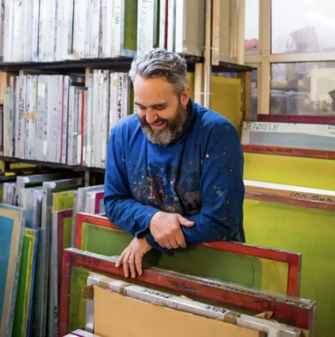 Dave Buonaguidi in the studio standing over his screen printing frames.