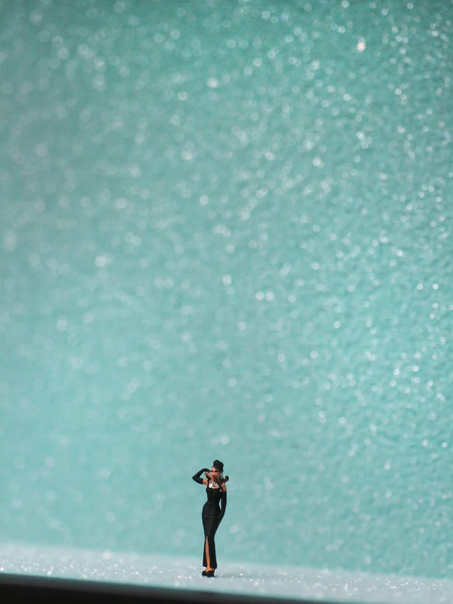 Miniature scene in an artbox showing a tiny Audrey Hepburn as Holly Golightly, against a sparkling backdrop of Tiffany’s duck-egg blue. 