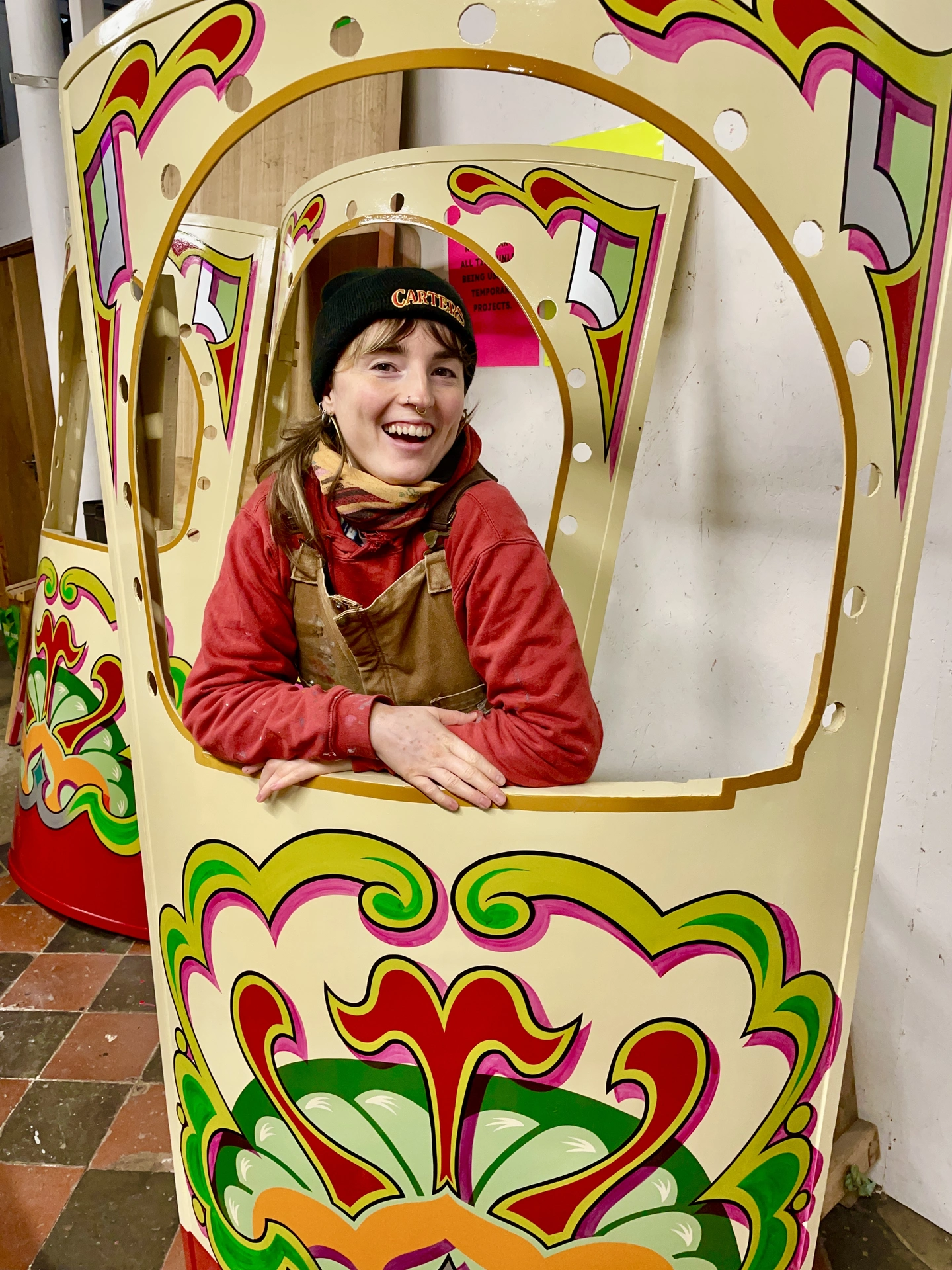 Jess pictured with a piece of a hand painted fairground ride