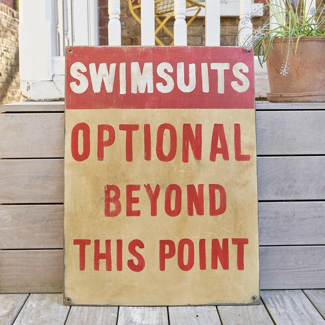 Swimsuits optional beyond this point sign